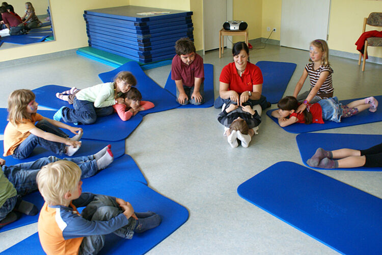 Kindersport auf blauen Turnmatten