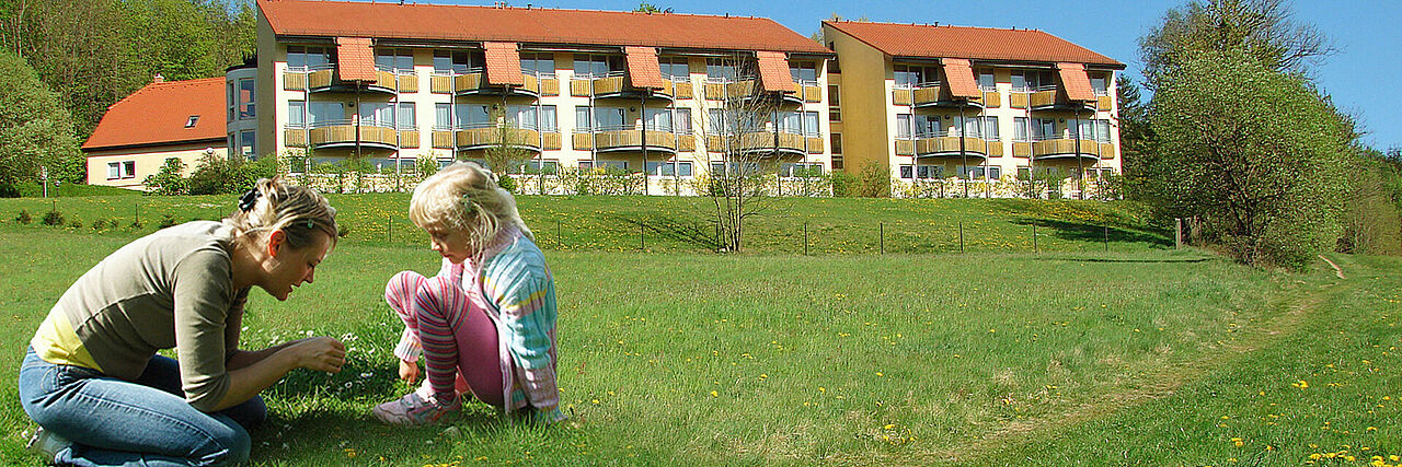 Blick auf das Bettenhaus im Sommer Mutter mit Kind im Vordergrund